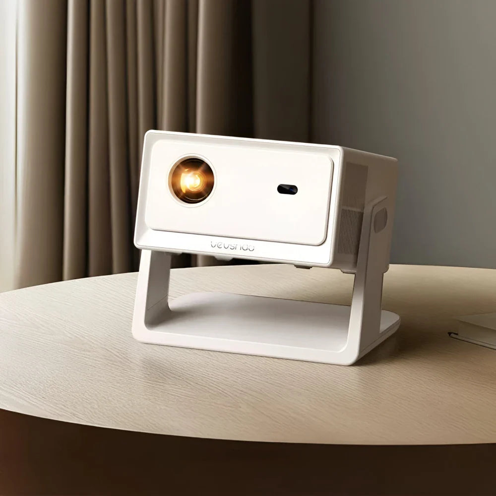 White portable projector on a wooden surface with a blurred curtain background